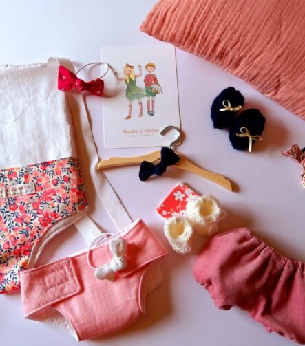 Tout le nécessaire pour s'occuper de sa poupée : porte-poupée, couche, chaussons, bloomer, etc.