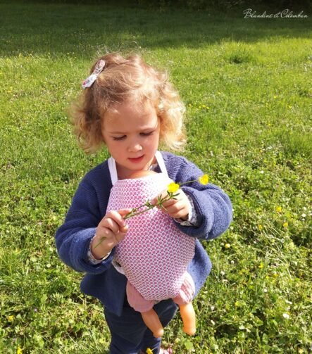 Porte-poupé rose et blanc pour enfant à partir de 3 ans.